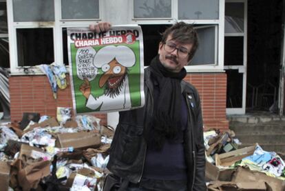 Un periodista muestra la portada del último ejemplar ante la sede de la redacción en París.