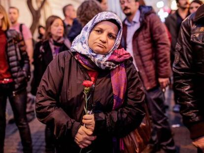 Una mujer turca sostiene un clavel durante un tributo a las víctimas del atentado de París en el exterior del consulado francés en Estambul.