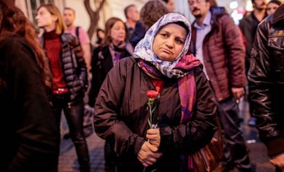 Una mujer turca sostiene un clavel durante un tributo a las víctimas del atentado de París en el exterior del consulado francés en Estambul.