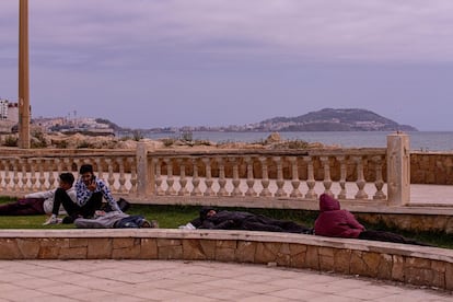 Un grupo de jóvenes descansa en un jardín próximo al paseo marítimo de Castillejos. Al fondo, el mar y la ciudad de Ceuta.