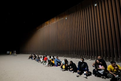 Migrantes esperan a ser procesados frente al muro fronterizo entre Mxico y Estados Unidos, en Yuma (Arizona), en 2022.