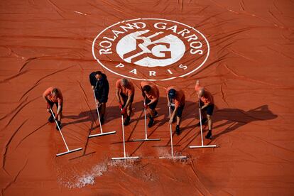 Empleados de pista retiran agua de la pista central en la última edición de Roland Garros.