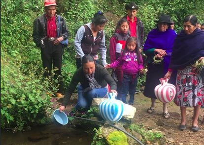 Algunos de los vecinos de Reforma cogen agua portable de la fuente. 