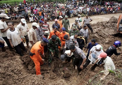 Policías y voluntarios buscan a posibles víctimas entre el barro tras el corrimiento de tierra ocurrido en la isla indonesia de Java, en el que al menos cinco personas han muerto y otras 14 permanecen desaparecidas.