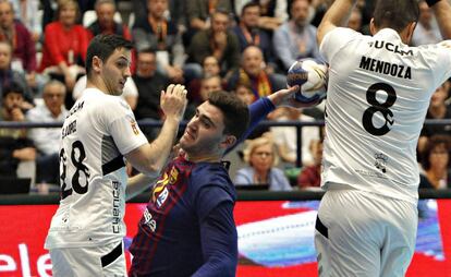 El jugador del Barcelona Fábregas (c) lanza ante David Mendoza (d) y Sergio López, del Cuenca.