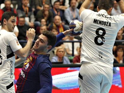 El jugador del Barcelona Fábregas (c) lanza ante David Mendoza (d) y Sergio López, del Cuenca.