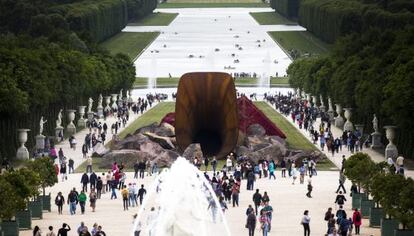 Varias personas observan la obra 'Dirty Corner' (sucia esquina), del escultor angloindio Anish Kapoor, uno de los artistas más influyentes del mundo, expuesta en los jardines del Palacio de Versalles, en París, Francia.