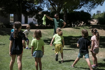 Niños jugando con su monitor en un campamento de verano en la provincia de Barcelona