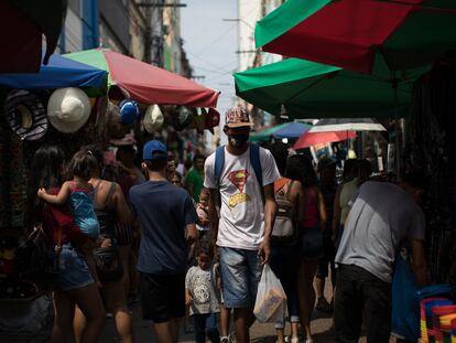 Un hombre y su hija caminan en medio de comercios callejeros en Manaus (Brasil), en una imagen de archivo.