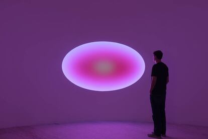 Aunque la piezas de vidrio elíptico curvo de Turrell está sujeta a la superficie de la pared, su presencia se extiende más allá del marco que la contiene, lo que recrea el efecto panorámico de mirar un campo infinito de color.