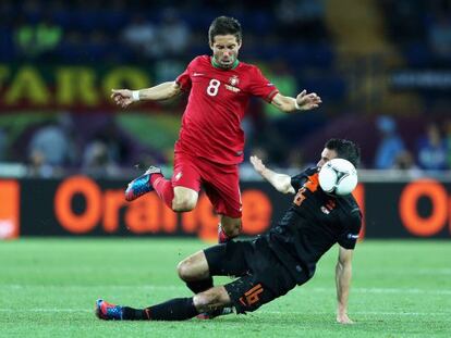 Moutinho salta ante Van Persie durante el partido de Portugal ante Holanda.