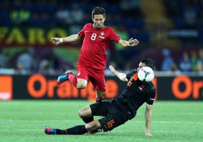 Moutinho salta ante Van Persie durante el partido de Portugal ante Holanda.