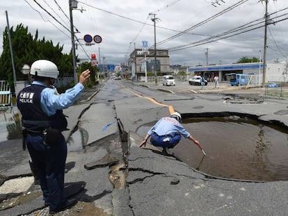 Policial examina cratera aberta pelo terremoto em uma rua de Takatsuki, ao norte de Osaka, na manhã desta segunda-feira