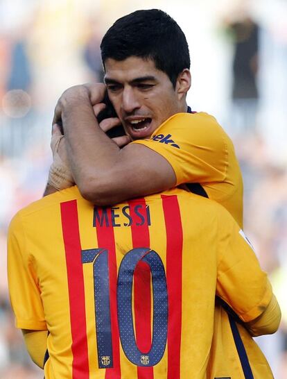 El delantero argentino del FC Barcelona Leo Messi (c) celebra con su compañero, el uruguayo Luis Suárez, su gol, el segundo del equipo ante el Málaga.