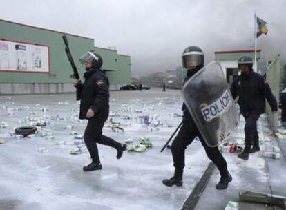 Agentes antidisturbios de la policía durante la carga contra los ganaderos concentrados ante la factoría de Leche Río