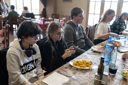 Una de las jóvenes lituanas hace una foto a un plato de paella.