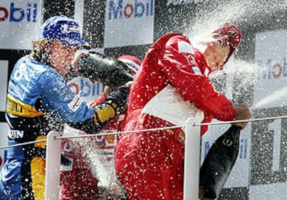 Fernando Alonso rocía con champán a Michael Schumacher en el podio de Magny Cours.