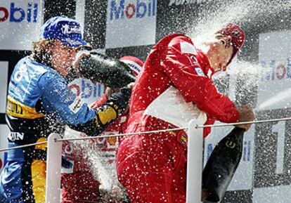 Fernando Alonso rocía con champán a Michael Schumacher en el podio de Magny Cours.