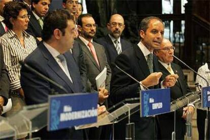 El presidente de la Generalitat, en el centro, entre los consejeros de Economía y Empresa.