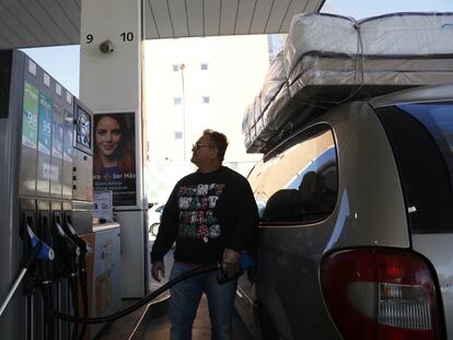 Un transportista echa gasolina en el coche con el que trabaja el primer día del descuento del Gobierno al precio de combustible.
