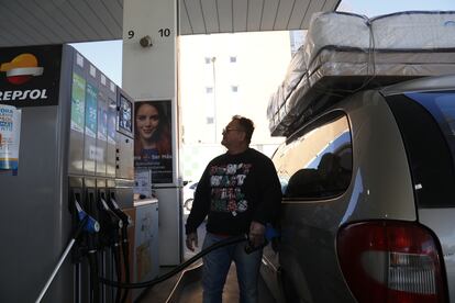 Un transportista echa gasolina en el coche con el que trabaja el primer día del descuento del Gobierno al precio de combustible.