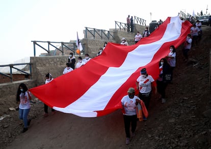 Simpatizantes del partido Fuerza Popular sostienen una bandera de Peru en el asentamiento Pomacocha-Manolo Castillo, en las afueras de Lima, en 2021.