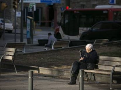 Un hombre sentado en un banco, en el Camp de l'Arpa.