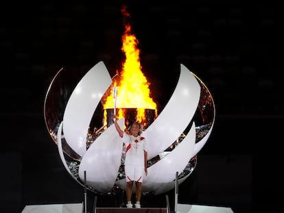 Naomi Osaka segura a tocha olímpica após acender a pira no Estádio Nacional de Tóquio.