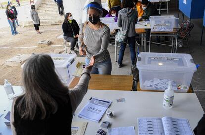 Quienes sí tienen prohibido salir de sus hogares son las personas con covid, que se enfrentan a altas multas si son sorprendidas en algún centro de votación. En la imagen, una mujer se prepara para votar en Santiago.