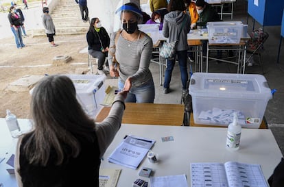 Quienes sí tienen prohibido salir de sus hogares son las personas con covid, que se enfrentan a altas multas si son sorprendidas en algún centro de votación. En la imagen, una mujer se prepara para votar en Santiago.