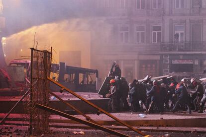 Manifestantes se protegen con escudos durante los enfrentamientos con la policía ucraniana en el centro de Kiev, 20 de enero de 2014.