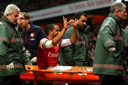 Walcott se dirige a los hinchas del Tottenham al salir en camilla.