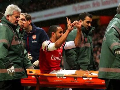 Walcott se dirige a los hinchas del Tottenham al salir en camilla.