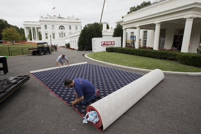 Varios trabajadores preparan la moqueta que se colocará en la Casa Blanca.
