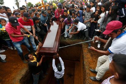 Los pobladores de Caldono bajan uno de los ataúdes con cuerdas para darle sepultura.