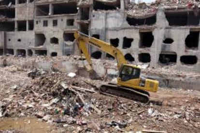 Una grúa limpia los escombros de la fábrica textil derrumbada en la localidad de Dacca, Bangladesh, cuando se cumplen 20 días de dicho derrumbe, que supuso el mayor siniestro industrial de la historia de Bangladesh.