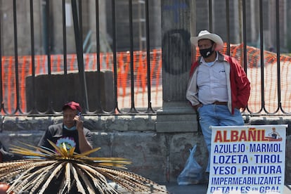 Dos hombres ofrecen sus servicios de trabajo en las rejas de la Catedral Metropolitana