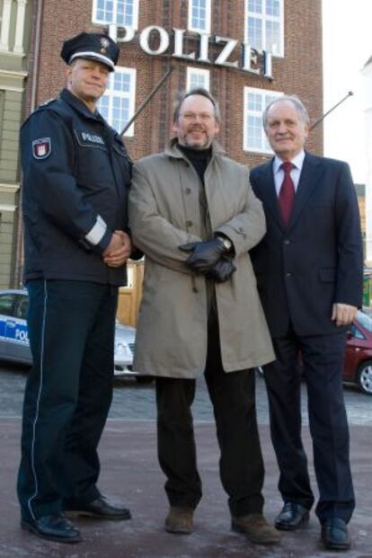 Craig Russell, en el centro, con dos agentes en Hamburgo.