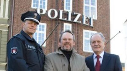 Craig Russell, en el centro, con dos agentes en Hamburgo.
