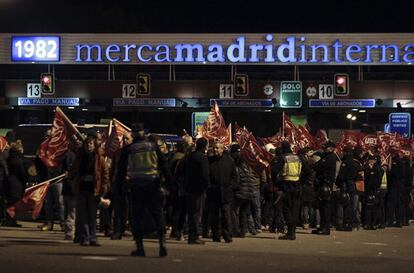 Miembros de UGT y CCOO, durante los piquetes informativos que han organizado esta noche a la entrada de Mercamadrid, en el comienzo de la huelga general 14N