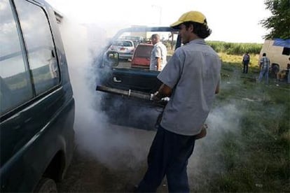 Un trabajador de la Sanidad cubana fumiga un coche en la provincia de Cienfuegos el pasado fin de semana.