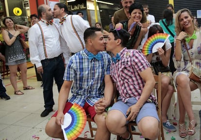 Un grupo de parejas se besan durante una boda multitudinaria en el Mercado de San Fernando en Madrid.
