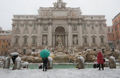 La ola de frío siberiano, llamada 'Burian', llegó ayer a Italia. En la imagen, varias personas hacen fotografías a la Fontana di Trevi durante la nevada en Roma (Italia), el 26 de febrero de 2018.