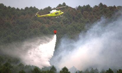 Un helicóptero trabaja en el incendio, cerca de la Veguilla.