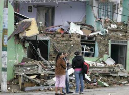 Una familia frente a su casa destruida