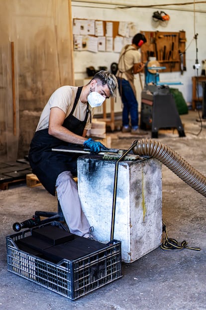 Alberto brushes a charred piece of wood. He wets it to stop the heat, then brushes it to remove excess carbon. Then, he touches it up with oil.

