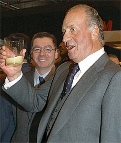 El Rey Juan Carlos prueba la sidra del pabellón de Asturias en la inauguración de la XXIII Feria Internacional de Turismo.