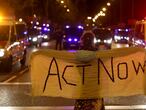 Una manifestante, con una pancarta con el lema "Act now" (actúa ahora, en castellano), este viernes en la marcha por el clima en Madrid.