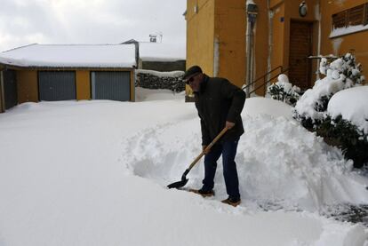 Un hombre retira con una pala la nieve del acceso a su vivienda en el municipio leonés de Puebla de Lillo.