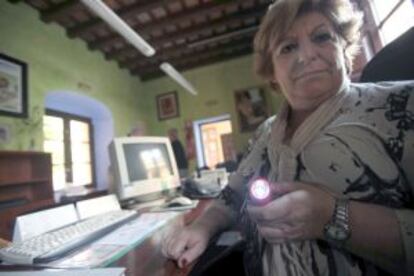 Una trabajadora de la Casa de la Cultura de los Barrios (Cádiz) usa linterna tras haberle cortado la luz por falta del pago del Ayuntamiento.